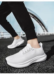 Close-up of white breathable mesh running shoes with thick cushioned soles on outdoor road