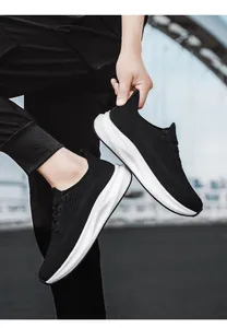 Close-up of black breathable mesh upper and white thick sole on sports running shoes