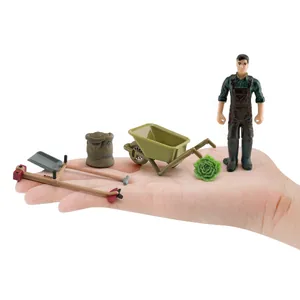 Set de granja en miniatura con figura de granjero y carretilla mostrados en la mano