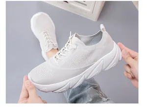 Close-up of lightweight breathable mesh sneakers showing flexible sole and white fabric texture