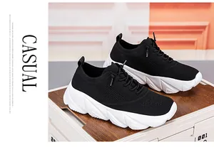 Detail of black breathable knit upper and thick white chunky sole on casual running shoe