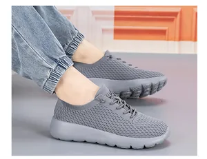 Detail of grey flyknit breathable mesh walking shoes on foot with EVA thick sole