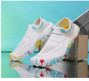 Dettaglio di scarpe acquatiche in maglia bianca con suola spessa antiscivolo e schizzi colorati