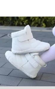Detail of white snow boot with plush faux fur lining and wide velcro strap closure