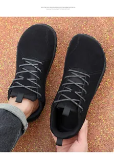 Macro shot of lightweight wide toe black barefoot sneakers with speckled laces and EVA sole