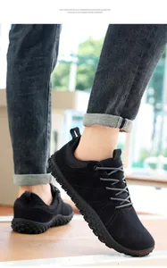 Dettaglio di sneakers da uomo in camoscio nero con suola in gomma e lacci intrecciati