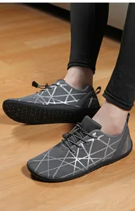 Close-up of breathable mesh barefoot sneakers with gray geometric lines on wooden floor