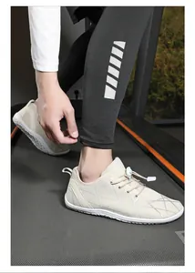 Close-up of beige breathable mesh sneakers with elastic toggle laces on a treadmill