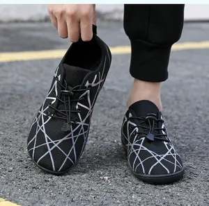 Close-up of black mesh breathable sneakers with silver geometric patterns and elastic laces