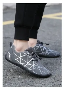 Detail of grey mesh sneakers with white geometric patterns and elastic drawstring laces