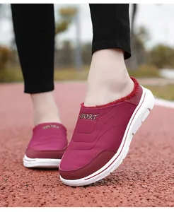 Macro shot of burgundy winter mule with warm red fur lining and gold SPORT embroidery