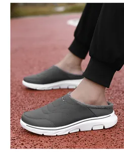 Detail of grey winter mule slippers with warm fur lining and thick white sport sole