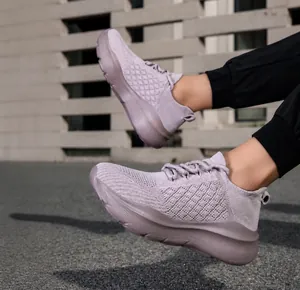 Détail de baskets en maille mauve à semelles épaisses dans un cadre urbain moderne