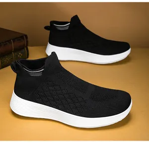 Detailed view of black breathable knit sock sneakers with thick white soles on warm background