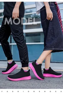 Close-up of black breathable slip-on sneakers with chunky pink soles for active wear