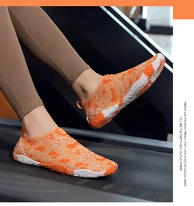 Detailopname van felle oranje blotevoetsschoenen op een loopband in de sportschool