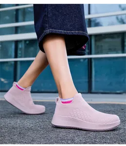 Side view of pink slip-on sneakers with breathable knit texture on a model walking outdoors