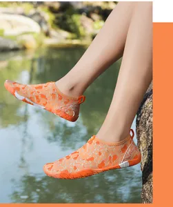 Oranje blotevoetenschoenen op rotsen bij het water tonen de uitstekende grip en flexibiliteit