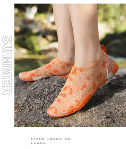 Outdoor wandelschoenen met oranje antislip rubberen zolen op rotsachtig terrein