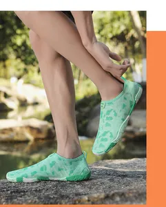 Close-up van mintgroene camouflage waterschoenen op rivierstenen met antislipzool