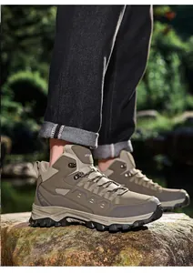 Detail of khaki mid-top hiking shoes featuring durable rubber soles on rocky terrain