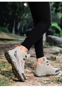 Outdoor hiking shoes in beige and pink shown on feet in a natural forest setting