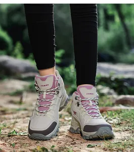Detail of high-top hiking boots with non-slip thick rubber soles and secure metal lace hooks