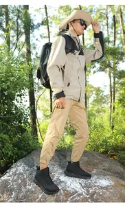 Wasserdichte Winterstiefel mit Wanderausrüstung auf felsigem Waldgelände gezeigt