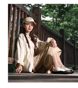 Photo lifestyle en plein air d'une chemise crème et jupe kaki avec des chaussures de marche