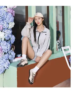 Portrait extérieur d'une femme en ensemble de sport gris clair avec chaussures de randonnée