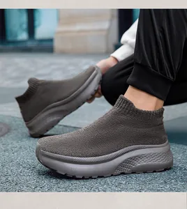 Foto all'aperto di sneaker a calzino in maglia grigio scuro con suole spesse su piedi