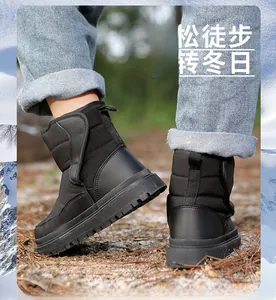Détail de bottes de neige noires pour enfants avec Velcro sur sol de forêt hiver