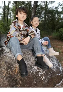 Enfants portant des bottes de neige chaudes en duvet matelassé en noir et beige à l'extérieur