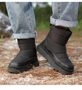 Gros plan de bottes de neige noires matelassées avec semelles épaisses antidérapantes
