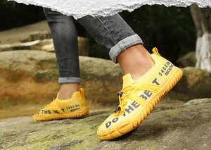 Outdoor macro view of yellow non-slip wading shoes with drawstring on rocky terrain