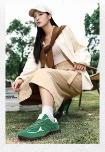 Outdoor shot of green hiking sneakers paired with khaki skirt and white mid-calf socks
