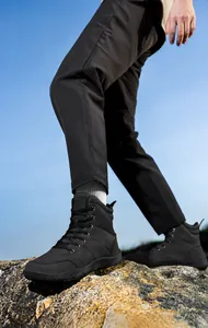 Scarpe da trekking alte nere con suole in gomma antiscivolo su terreni rocciosi all'aperto