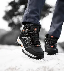 Scarponi da trekking a taglio medio con suole antiscivolo che camminano sulla neve