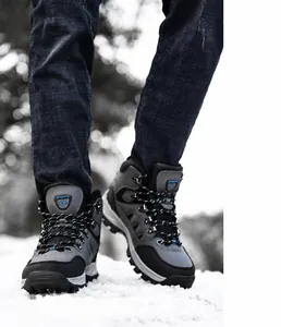 Dettaglio scarponi da trekking grigi e neri sulla neve con logo sportivo outdoor