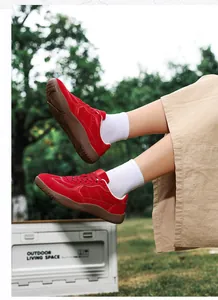 Detail of red suede hiking shoes with thick rubber outsole and anti-slip traction pattern