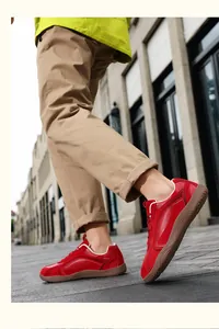 Detalle de zapatillas barefoot de cuero rojo con suela de goma para hombre en la calle