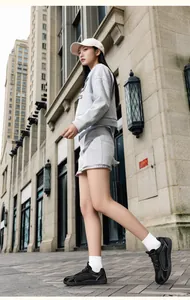 Vista de calle de una mujer con un conjunto de sudadera de punto gris claro y minifalda