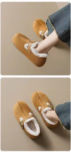 Λεπτομέρεια από καφέ σουέτ Birkenstock mules με ζεστή λευκή γούνινη επένδυση και αγκράφα