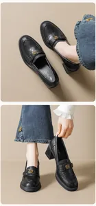 Detailaufnahme der matten schwarzen Leder-Loafer mit eleganter goldener Kamelien-Schnalle