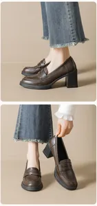 Details von dunkelbraunen Leder-Loafern mit Blockabsatz und ausgefransten Jeans
