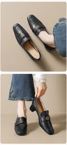 Macro-opname van zwarte leren loafers met gouden bloemgesp en vierkante neus detail