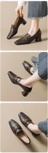 Detail van donkerbruine loafers met vierkante neus, gouden gesp en een stevige blokhak