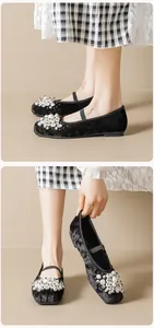 Detail of black velvet Mary Jane flat shoes featuring elegant pearl beads and lace accents