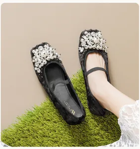 Detailed close-up of black velvet ballet flats with pearls and sparkling rhinestones