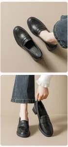 Detail of retro black leather platform loafers with chunky mid-heels and buckle detail